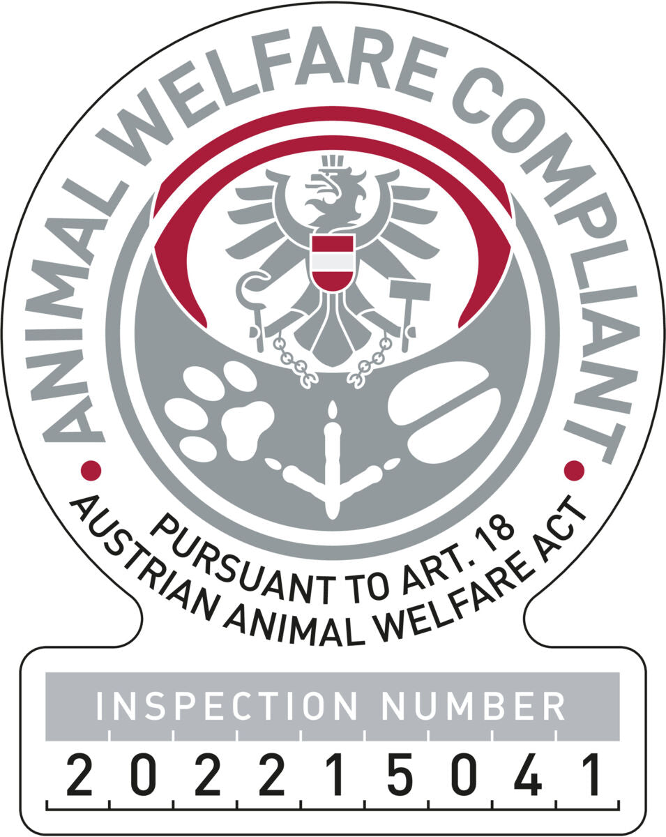 Rundes Emblem mit Adler, Pfotenabdruck und Text: "Animal Welfare Compliant" und "Pursuant to Art. 18 Austrian Animal Welfare Act".