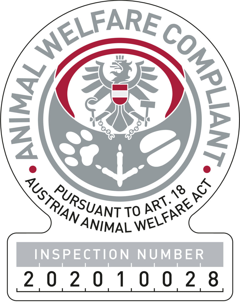 Rundes Emblem mit Adler, Tatzenabdrücken, griechischer Spalte, Text: "ANIMAL WELFARE COMPLIANT" und Inspektionsnummer.