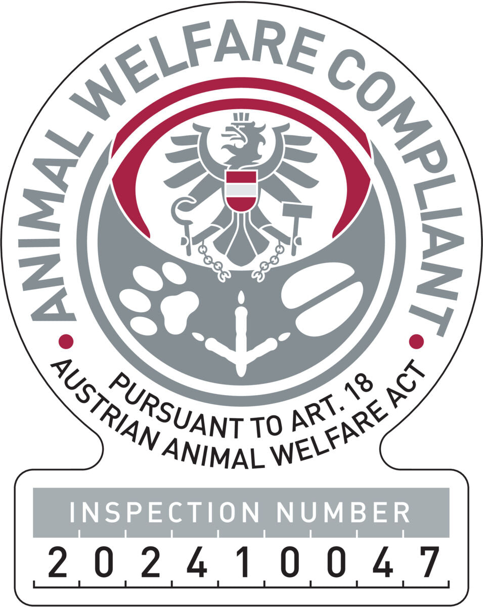Rundes Emblem mit Adler, Tatzenabdruck, Hufeisen und Text "ANIMAL WELFARE COMPLIANT" in Grau und Rot, Inspektionsnummer 202410047.
