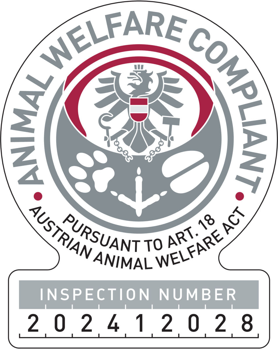 Abzeichen mit österreichischem Adler, Text "Animal Welfare Compliant" und Prüfnummer 202412028 in Grau und Rot.