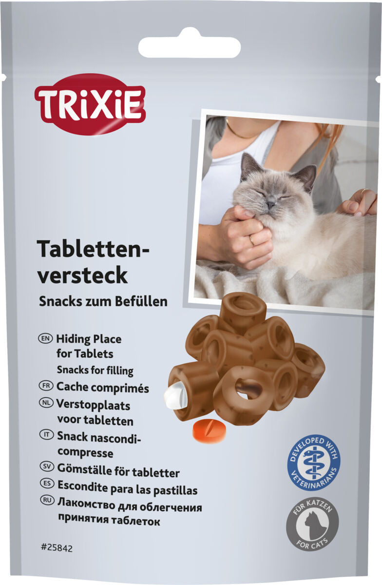 Verpackung mit braunen Snacks zum Befüllen für Tabletten, Katze wird gestreichelt, Markenlogo oben links.