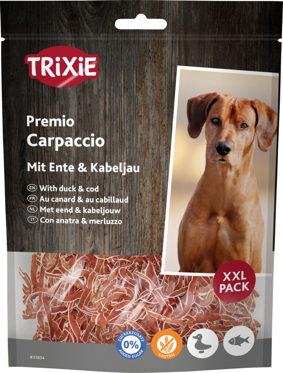 Eine Tüte Hundefutter von Trixie mit der Aufschrift "Premio Carpaccio mit Ente & Kabeljau", daneben Bild eines Hundes.