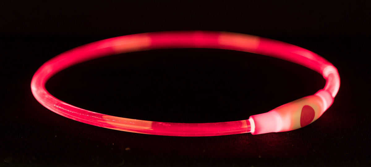 Leuchtender roter Ring mit Lichtschalter auf dunklem Hintergrund.