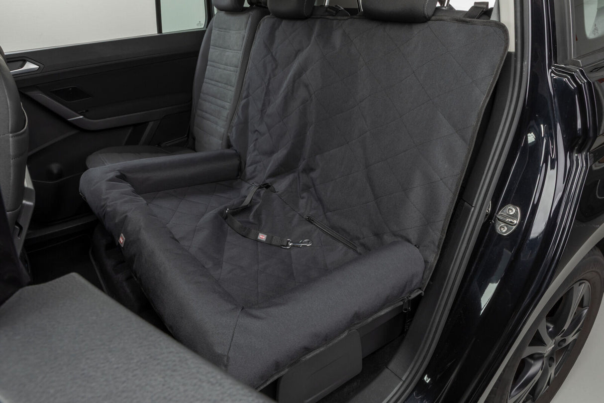 Schwarze Autoschondecke schützt die Rückbank eines Fahrzeugs mit offenem Autotür.