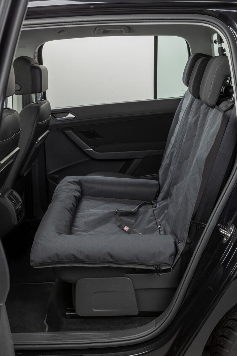 Schwarzer Autositzbezug mit gepolstertem Hundeplatz in der Rückbank eines Autos.