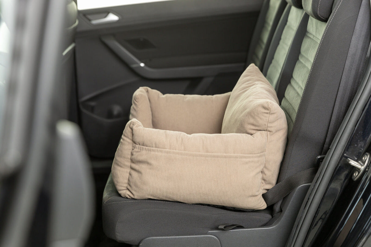 Beiger, weich gepolsterter Sitz auf einem Autokindersitz in einem Fahrzeug platziert.