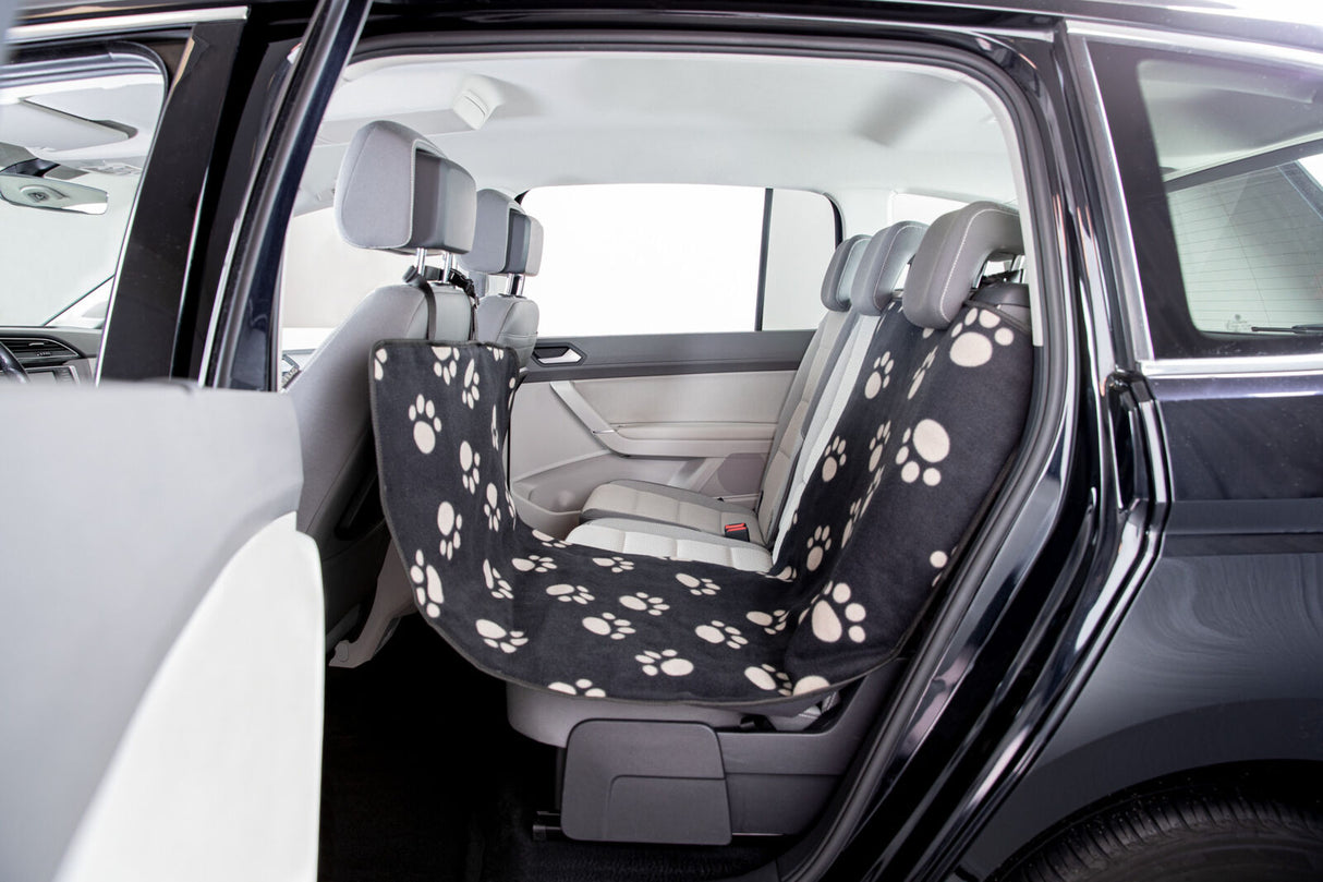 Auto-Innenraum mit grauen Sitzen und schwarzer, pfotenbedruckter Schonbezugmatte über der Rückbank.