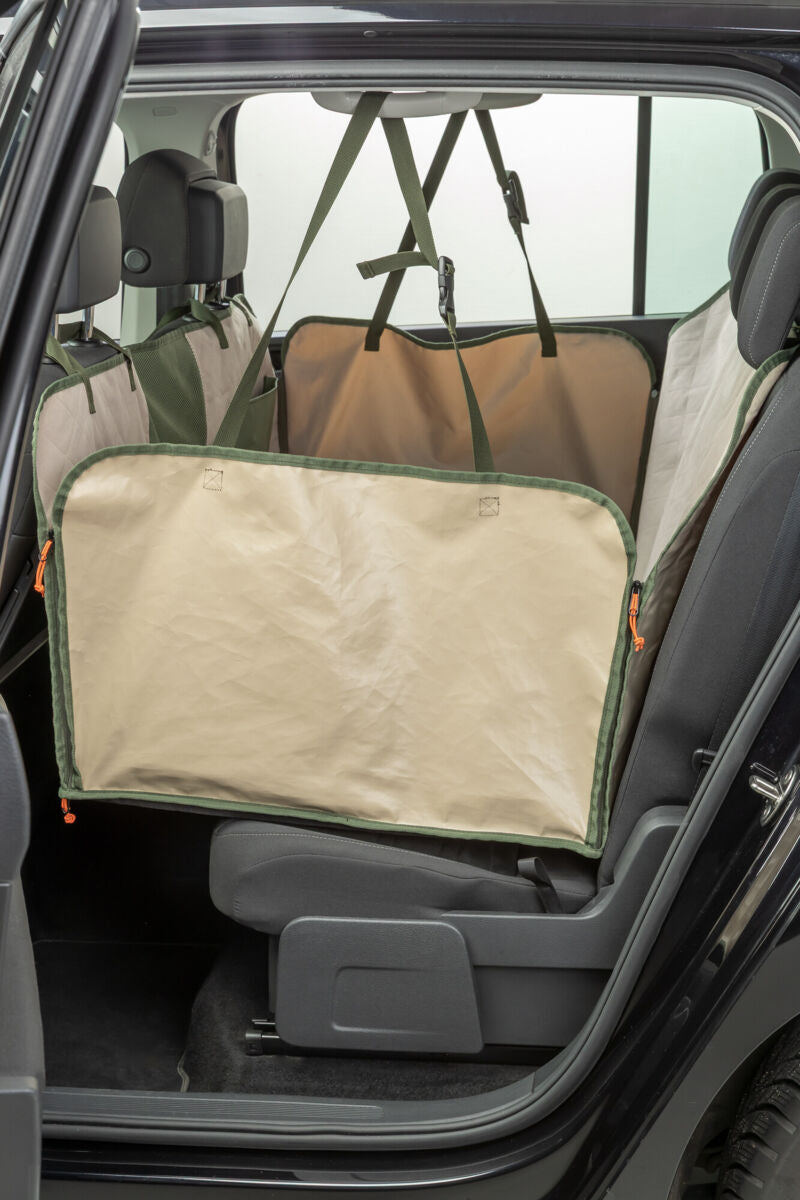 Schützende Rücksitzabdeckung in beige und grün, befestigt im Inneren eines Autos.