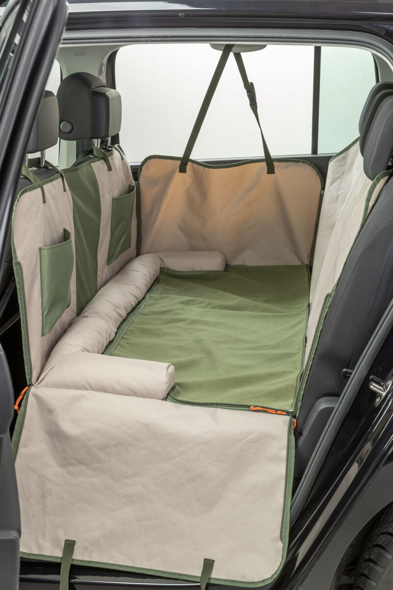 Grüne und beige Autoschondecke schützt den Rücksitz mit seitlichen Taschen und Befestigungsgurten.