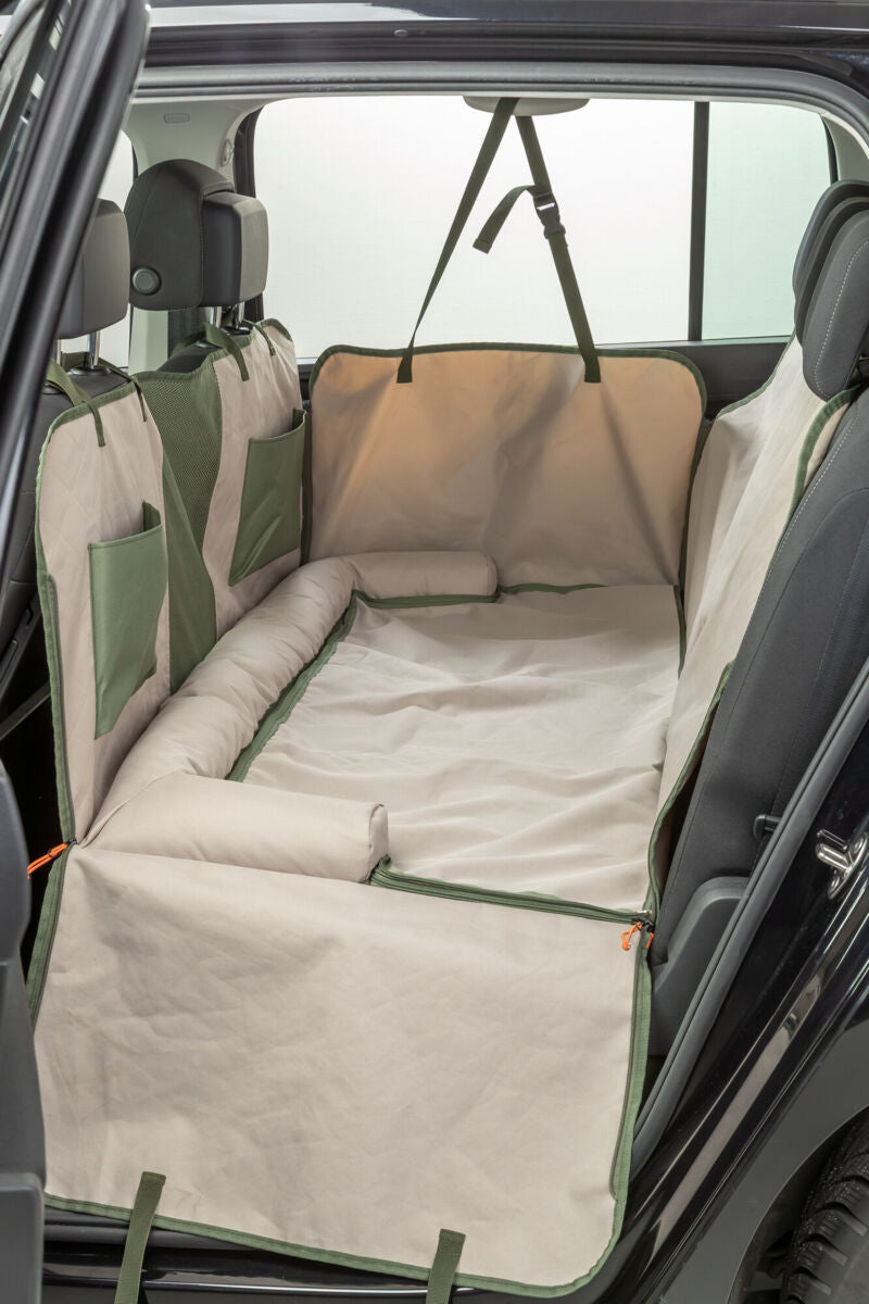 Beige Autoschondecke mit grünen Akzenten, ausgelegt im Rücksitzbereich eines Fahrzeugs.