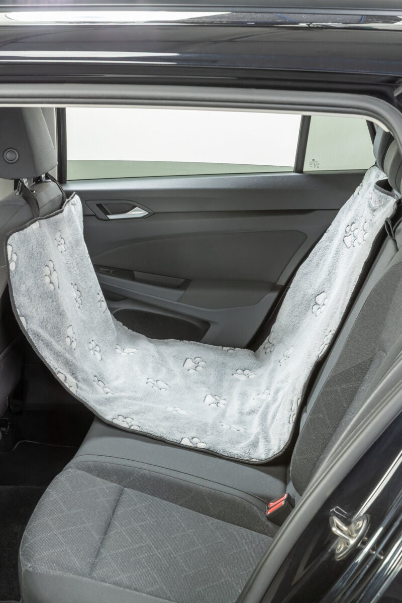 Graue Autoschondecke mit Pfotenmuster hängt auf dem Rücksitz eines Autos.