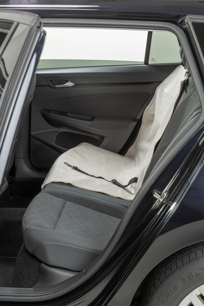 Autositzbezug in Beige auf Rücksitz eines geöffneten Autos sichtbar.