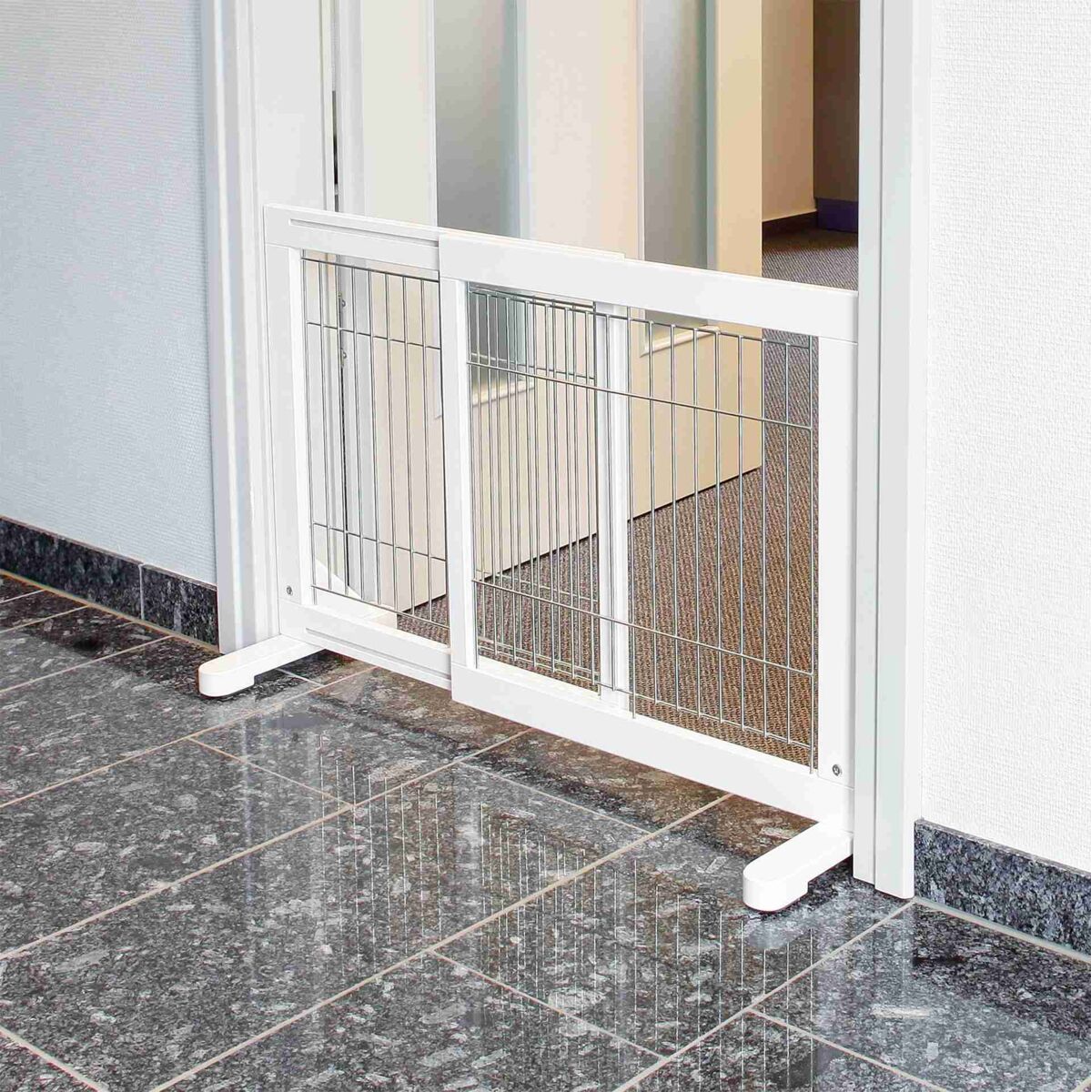 Weiße Türschutzgitter aus Metall und Kunststoff mit vertikalen Stäben in einem Türrahmen auf glänzendem Fliesenboden.