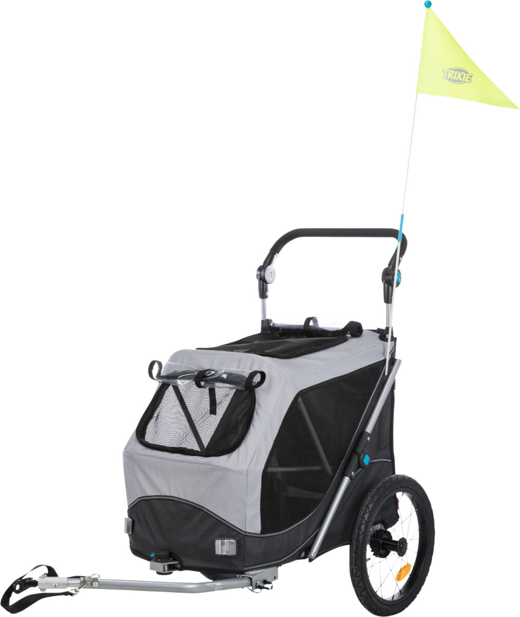 Grauer Fahrradanhänger mit schwarzem Netzfenster und gelber Fahne auf schwarzem Gestell, zwei Räder.