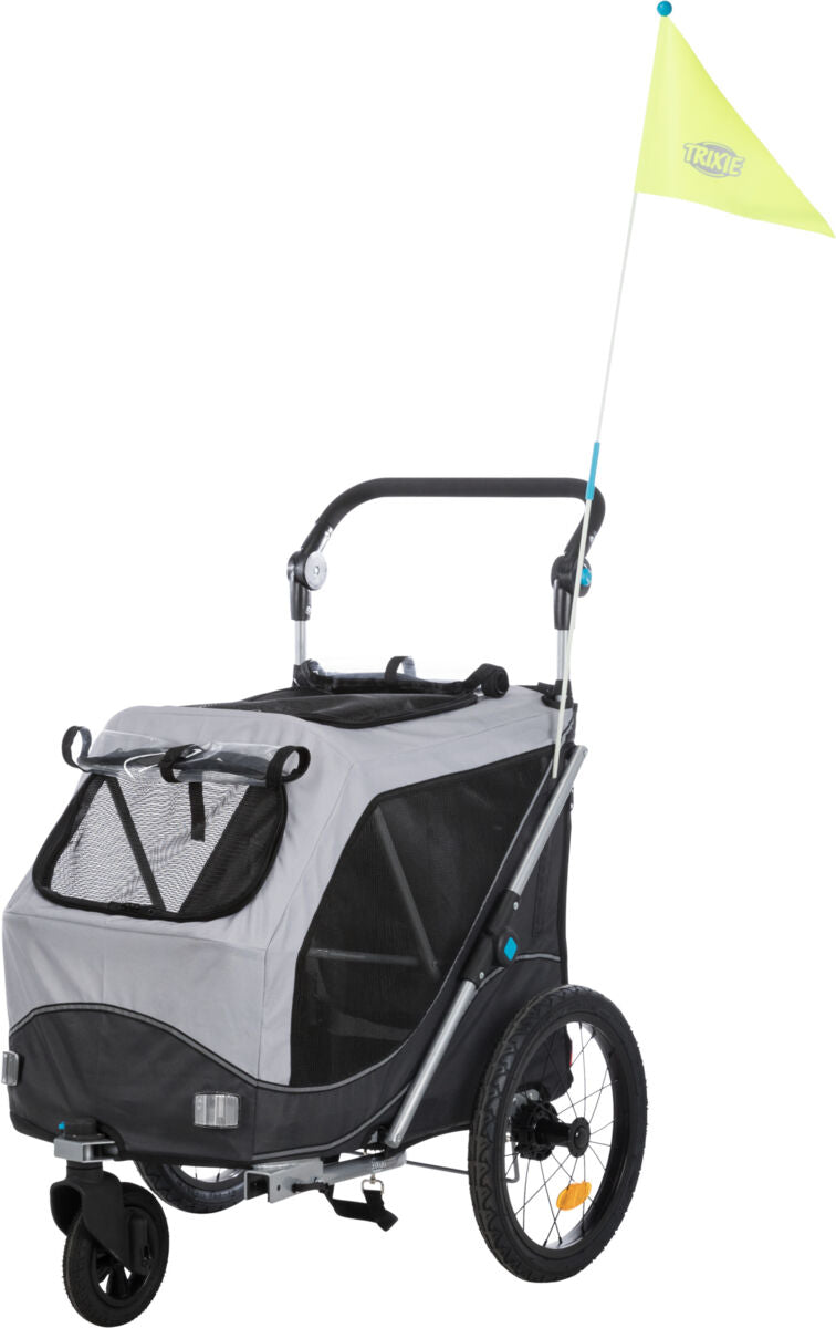 Grauer Fahrradanhänger mit schwarzem Rahmen, zwei großen Rädern, einem kleinen Vorderrad und gelber Fahne.