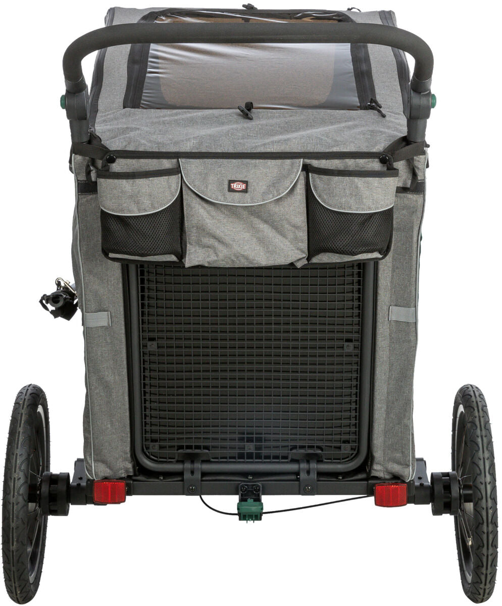 Ein grauer Fahrradanhänger mit zwei Rädern, oben mit Netzabdeckung und Griff, auf Asphalt stehend.