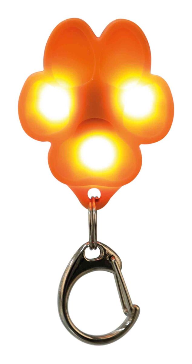 Ein orange leuchtender Anhänger in Form einer Tatze mit vier sichtbaren Lichtern und einem silbernen Karabiner.