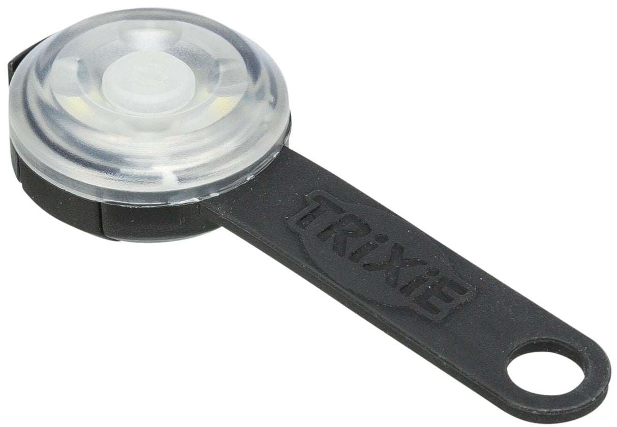 Rundes, transparentes Blinklicht mit schwarzem Gummiband, darauf der Schriftzug "Trixie" erkennbar.