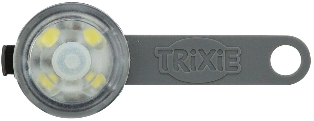 Graue, runde LED-Leuchte mit transparentem Gehäuse und gummierter Öse, darauf der Schriftzug "TRIXIE".
