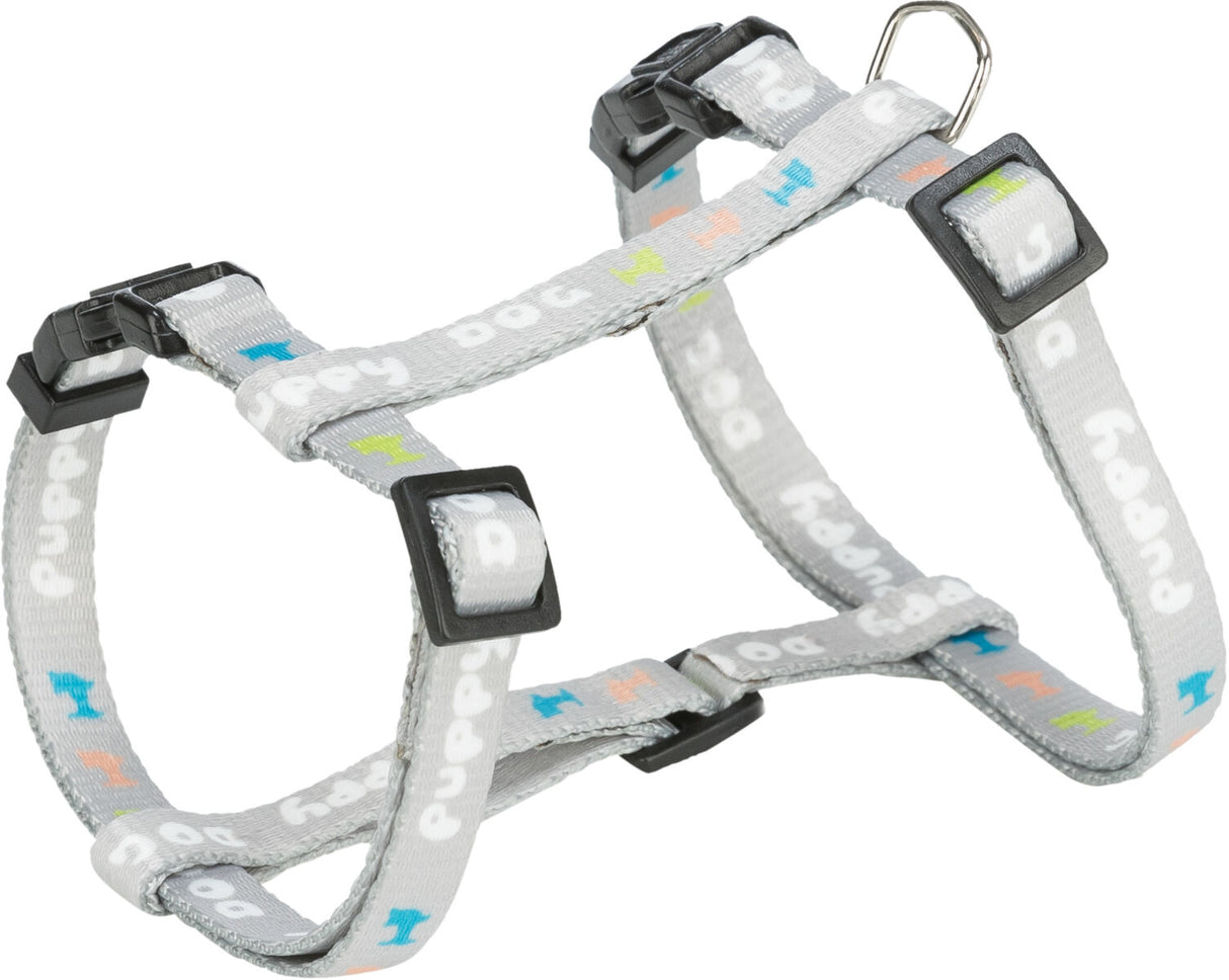 Graues Hundegeschirr mit bunten Mustern und schwarzem Verschluss, Aufschrift "puppy" mehrfach sichtbar.