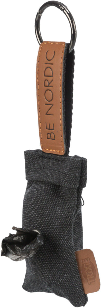 Grauer Stoffspender mit schwarzem Plastikbeutel, brauner Lederlasche mit "BE NORDIC", Metallring oben.