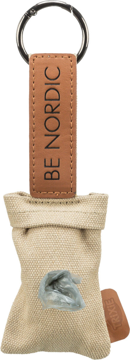 Beigefarbener Schlüsselanhänger mit Text "BE NORDIC" auf braunem Lederetikett und Plastikbeutelspender.