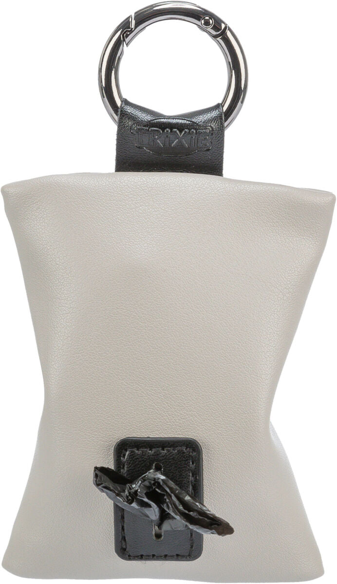 Graue Tasche mit Metallring, schwarzer Aufhängung und sichtbarem Text "TRIXIE", unten herausstehende schwarze Tüte.