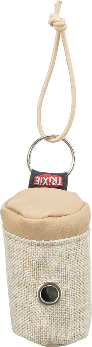 Beiger Behälter mit Deckel und silbernem Ring, oben mit Kordel, an der Seite eine Metallöffnung, Text "TRIXIE".