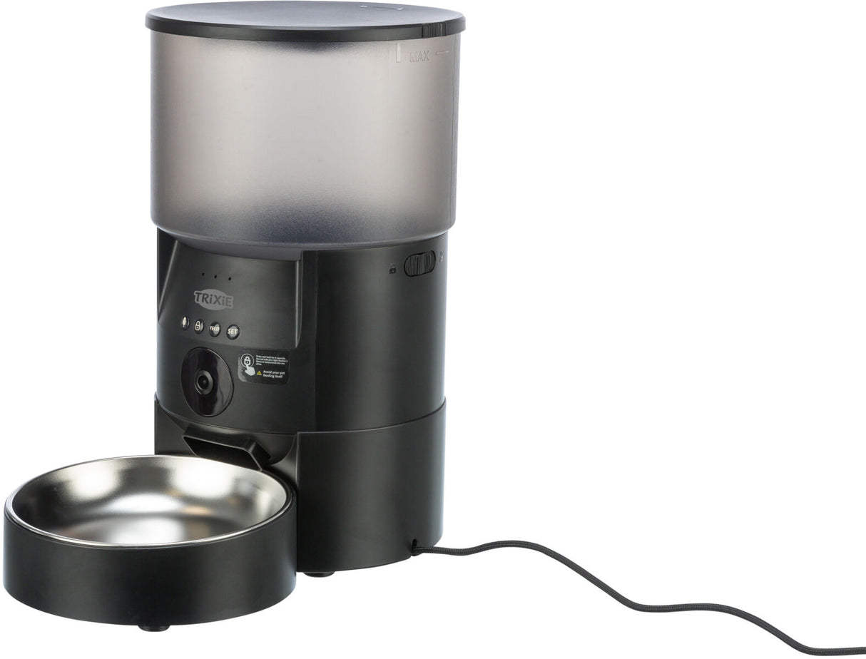 Automatischer Futterautomat in Schwarz mit silberner Futterschale, Netzkabel angeschlossen, Trixie-Logo sichtbar.