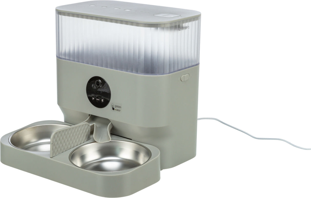 Automatischer Futternapfspender mit zwei silbernen Schüsseln und durchsichtigem Behälter, an Stromkabel angeschlossen.