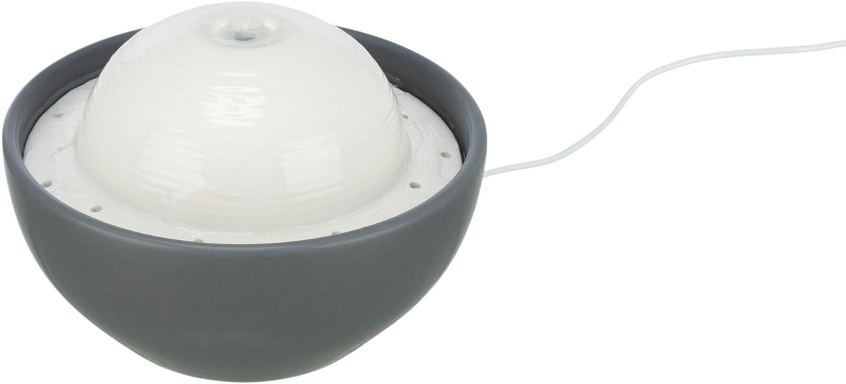 Grauer, runder Trinkbrunnen mit weißem, kugelförmigem Aufsatz und Kabel zum Anschluss.