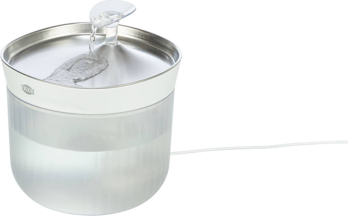 Runder, transparenter Wasserspender mit silbernem Deckel und leichtem Wasserfluss, weißes Kabel sichtbar.