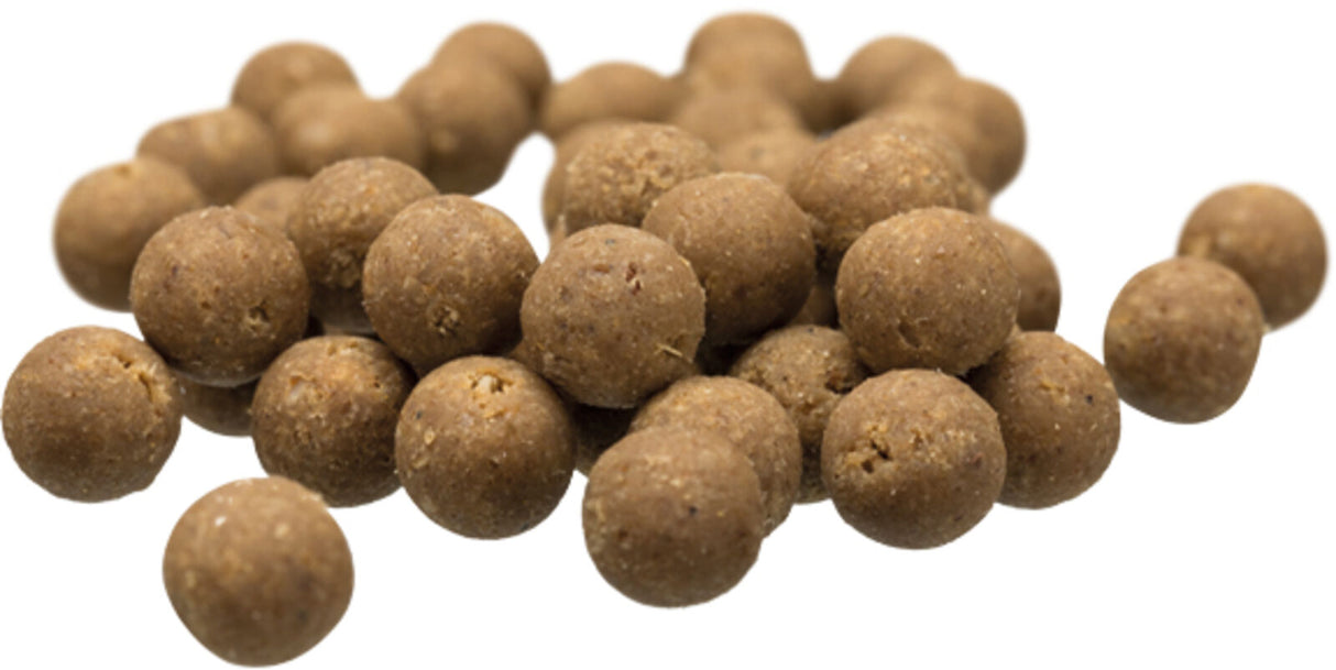 Braune, kugelförmige Futterpellets in verschiedenen Größen auf weißem Hintergrund verstreut.