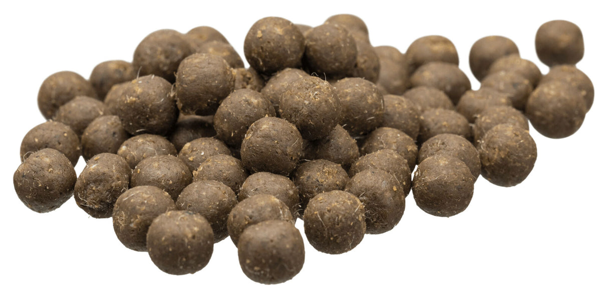 Braune kugelförmige Pellets in einem Haufen auf weißem Hintergrund, erdiges Aussehen.