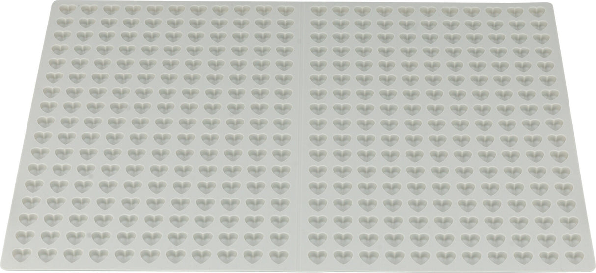 Weiße Silikonform mit vielen herzförmigen Vertiefungen auf einer flachen Oberfläche.