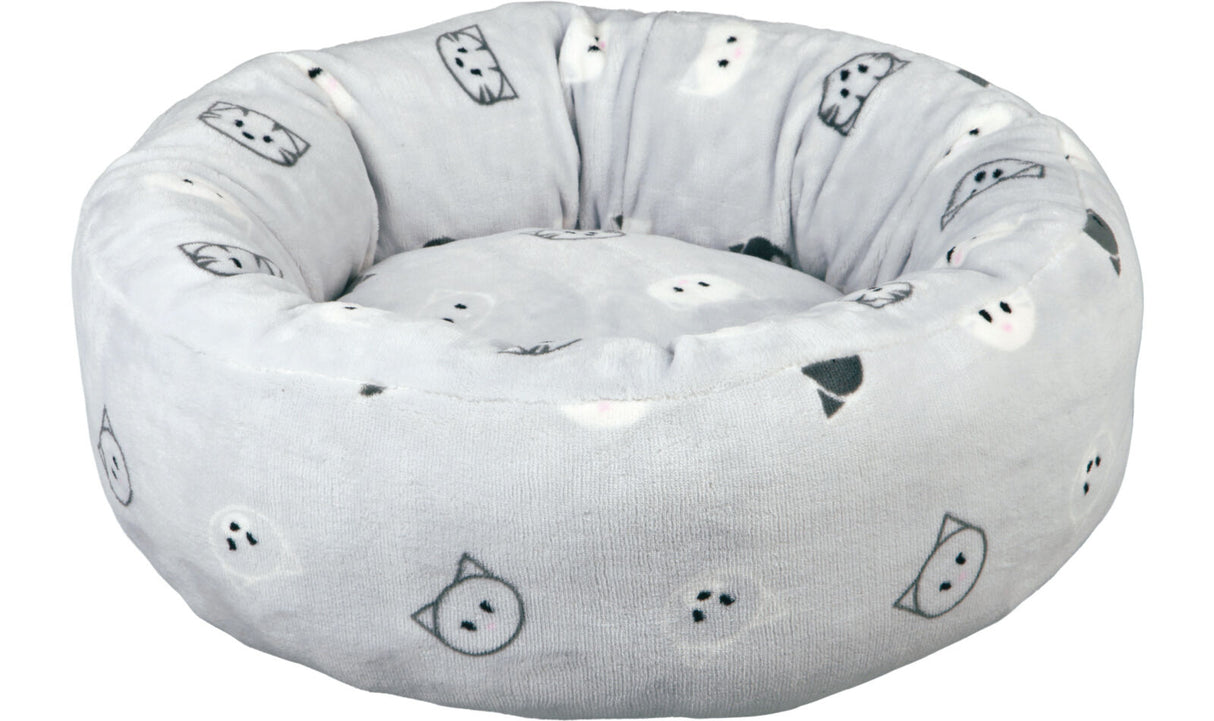 Rundes, graues, gepolstertes Bett mit schwarzen und weißen Katzengesichtern als Muster.