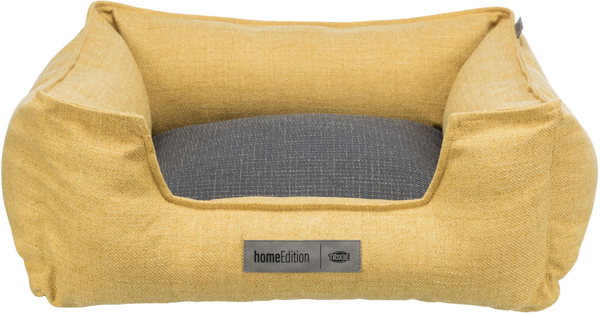 Rechteckiges, gelbes Haustierbett mit grauem Kissen und Label "homeEdition TRIXIE" auf der Vorderseite.