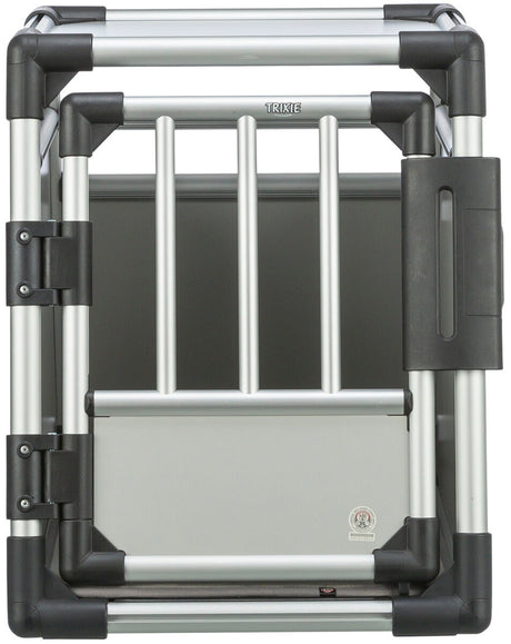Silberne Hundetransportbox mit schwarzen Ecken und einem Gitter aus vertikalen Stäben, die das Logo "TRIXIE" zeigt.