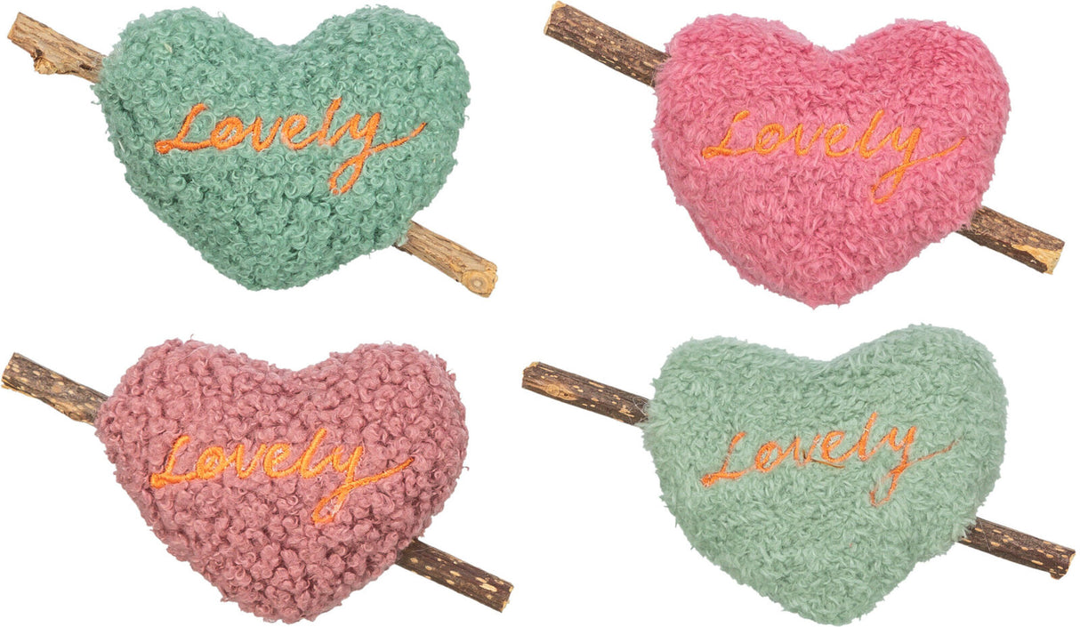 Vier herzförmige, flauschige Kissen in Grün und Rosa mit dem Wort "Lovely" darauf, an einem Holzstab befestigt.