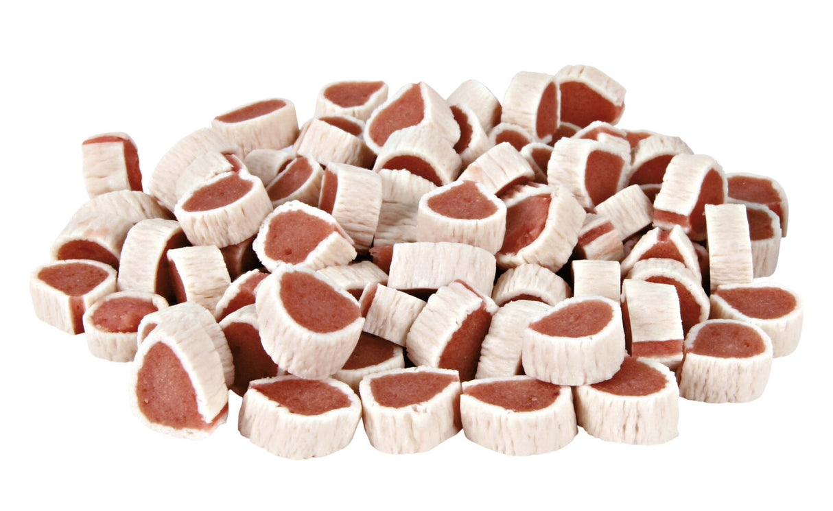 Runde, cremefarbene Snacks mit rosa Füllung, gestapelt auf einer weißen Oberfläche.