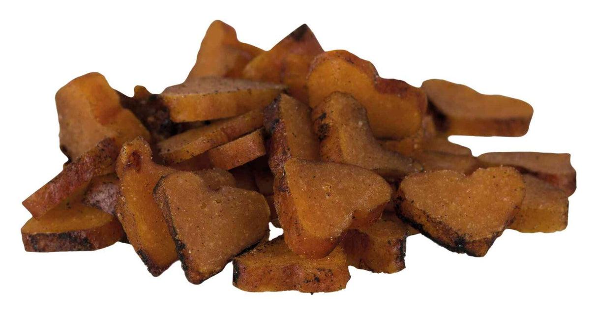 Ein Haufen herzförmiger, brauner Snacks oder Kekse mit leicht unregelmäßiger Oberfläche auf weißem Hintergrund.