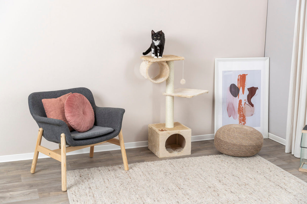 Katzenkratzbaum mit zwei Plattformen, auf dem eine schwarz-weiße Katze sitzt, daneben ein Sessel mit rosa Kissen.