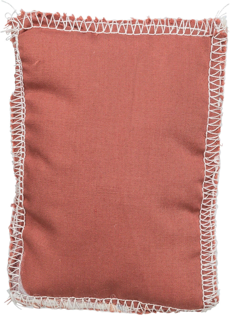 Rechteckiges rötliches Stoffkissen mit sichtbaren weißen Nähten an den Rändern.