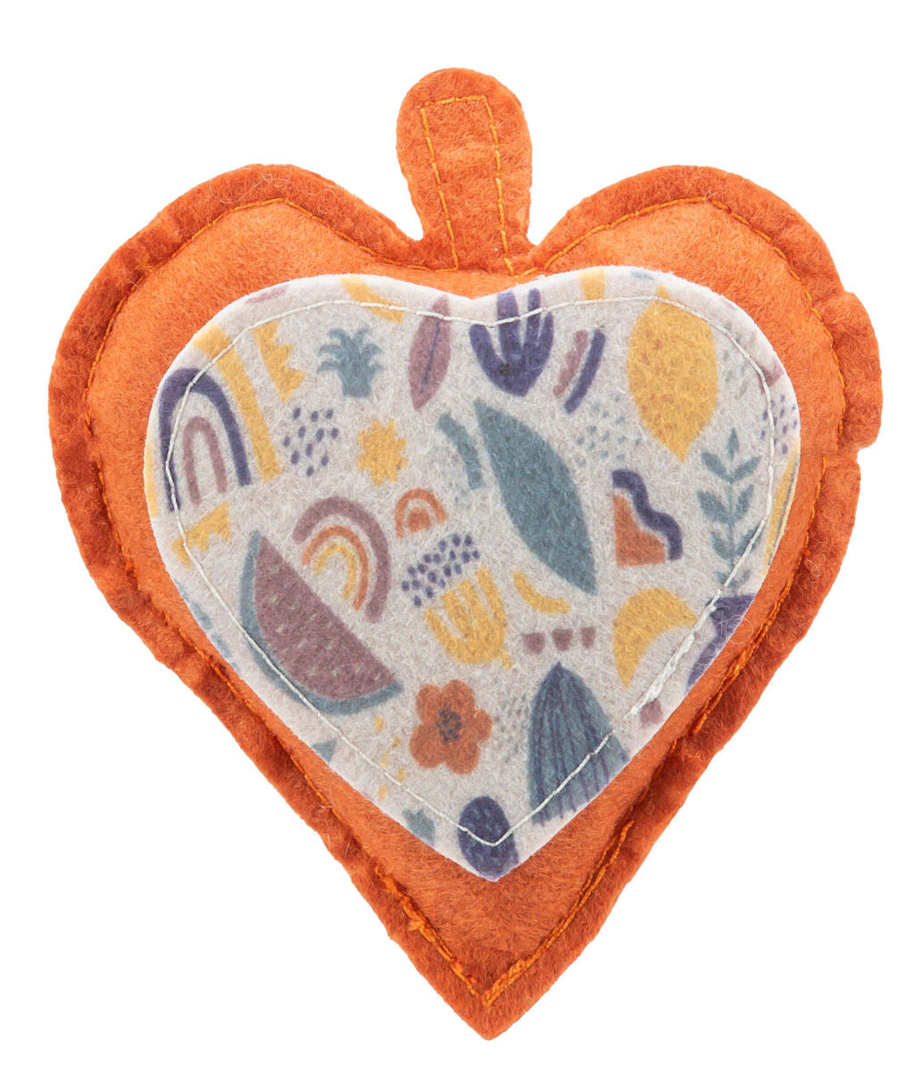 Herzförmiges Kissen in Orange mit buntem, gemustertem Stoffeinsatz, geometrische Muster und Symbole.