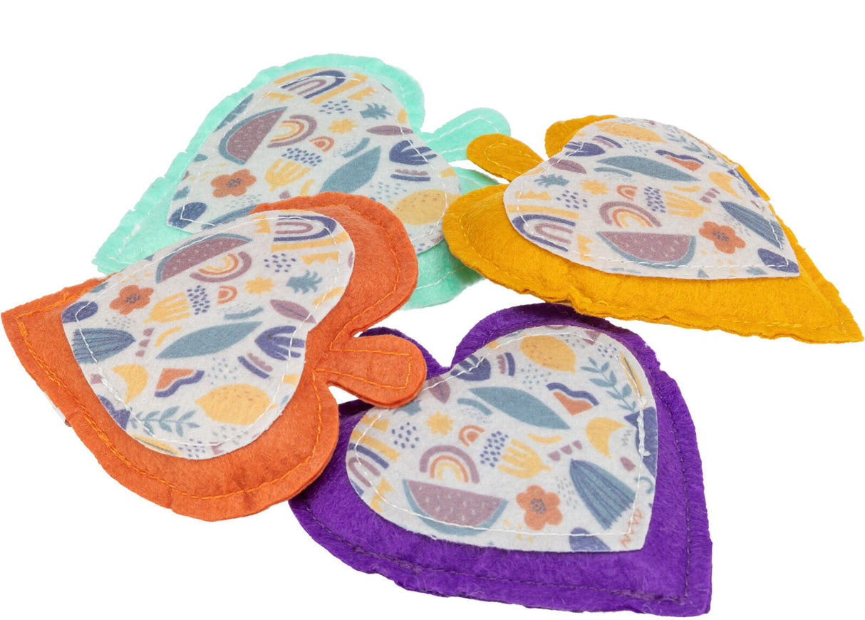 Vier herzförmige Stoffstücke mit buntem Muster, in Orange, Gelb, Lila und Mintgrün.