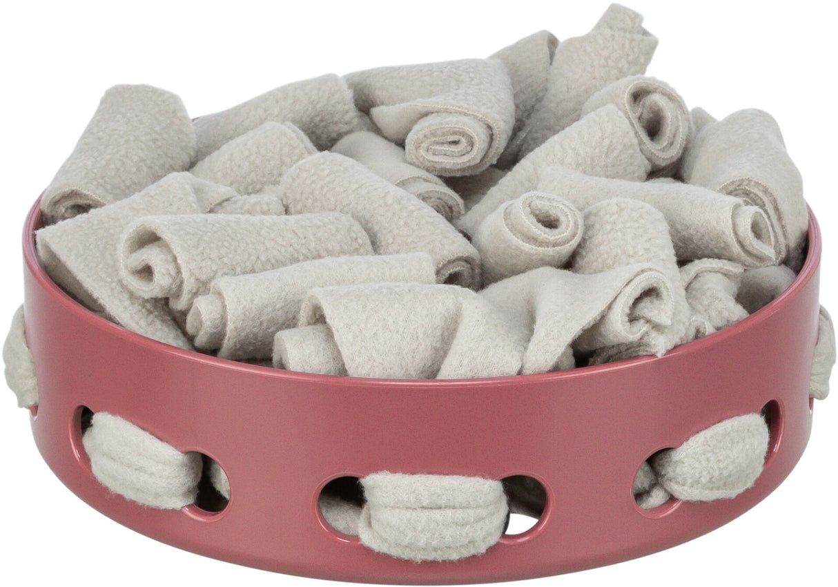 Runde rosafarbene Schale mit grauen Stoffrollen gefüllt, Schlitze an der Seite sichtbar.