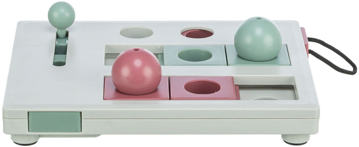 Ein rechteckiges, weißes Spielbrett mit pastellfarbenen Elementen, einschließlich rosa und grün, und Schiebemechanismen.
