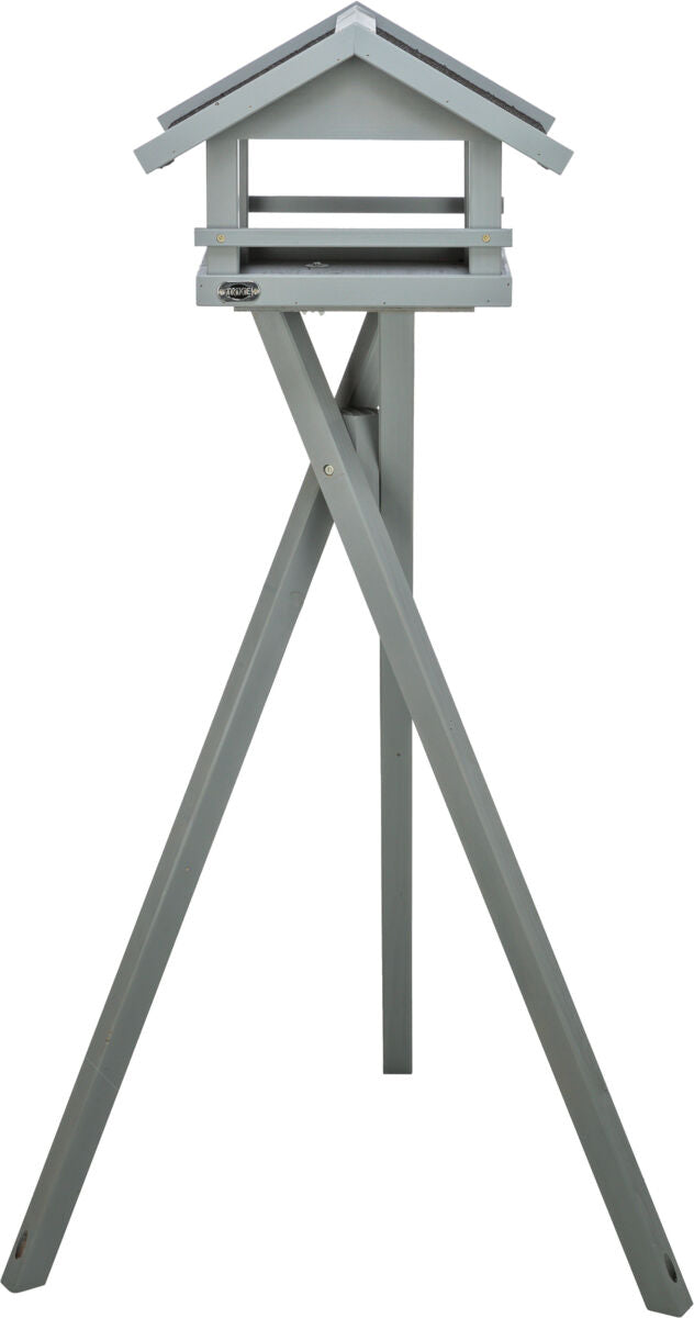 Graues Vogelhaus in dreieckiger Form auf einem hohen, dreibeinigen Ständer aus Holz.