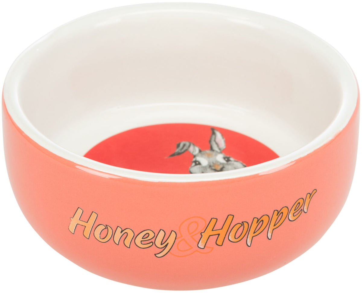 Rosa Napf mit der Aufschrift "Honey & Hopper" und einem Hasenbild im Innenboden vor rotem Hintergrund.