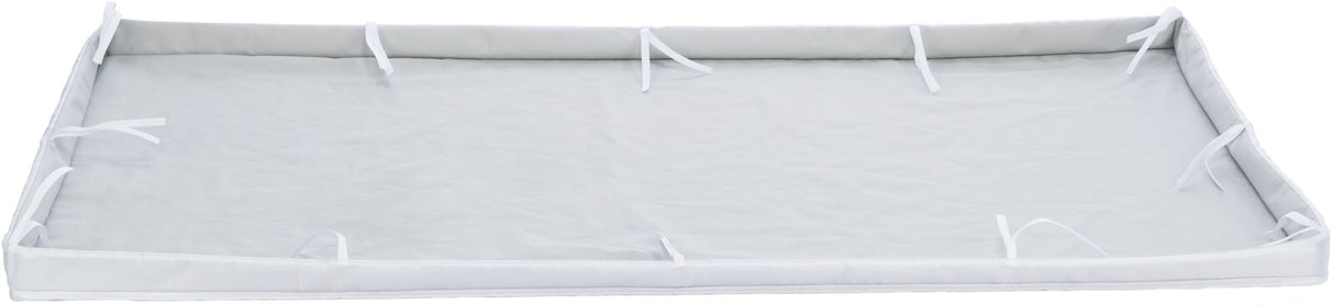 Rechteckige, flache, weiße Unterlage mit seitlichen Klappen und Bändchen an den Kanten zur Befestigung.